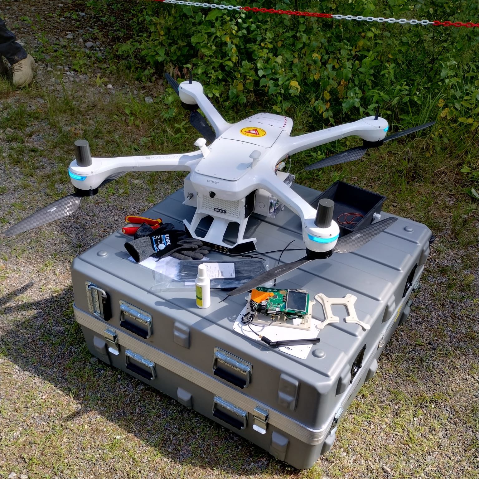 A drone with equipment on top of its container outdoors